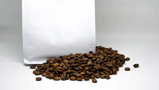 A premium coffee bag sealed and standing tall on a soft beige backdrop with rich coffee brown shadows.