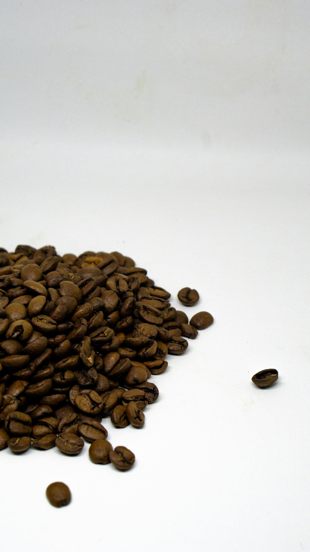 a pile of coffee beans sitting on top of a white table