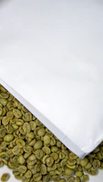 Fresh green coffee beans neatly arranged on matte forest green surface