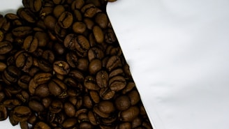 Close-up of a beautifully crafted single-serve coffee pack with rich roasted beans spilling beside it