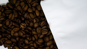 Close-up of freshly roasted coffee beans spilling from a burlap sack.