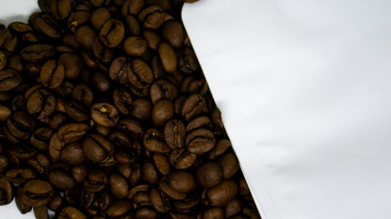 Close-up of glossy roasted coffee beans spilling from a burlap sack on a wooden table