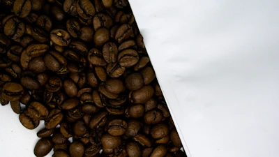 Close-up of freshly roasted coffee beans spilling from a burlap sack.