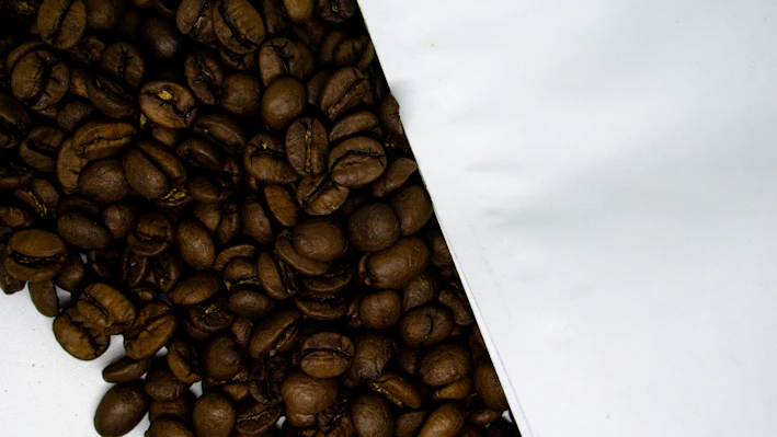 Close-up of freshly roasted coffee beans spilling from a burlap sack