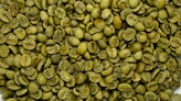 a pile of green coffee beans sitting on top of a table