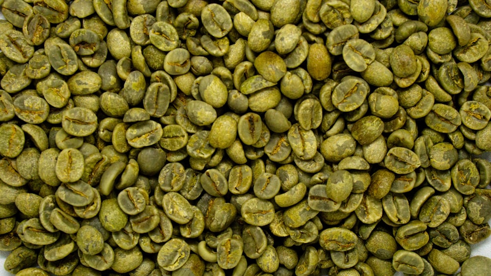 a pile of green coffee beans sitting on top of a table