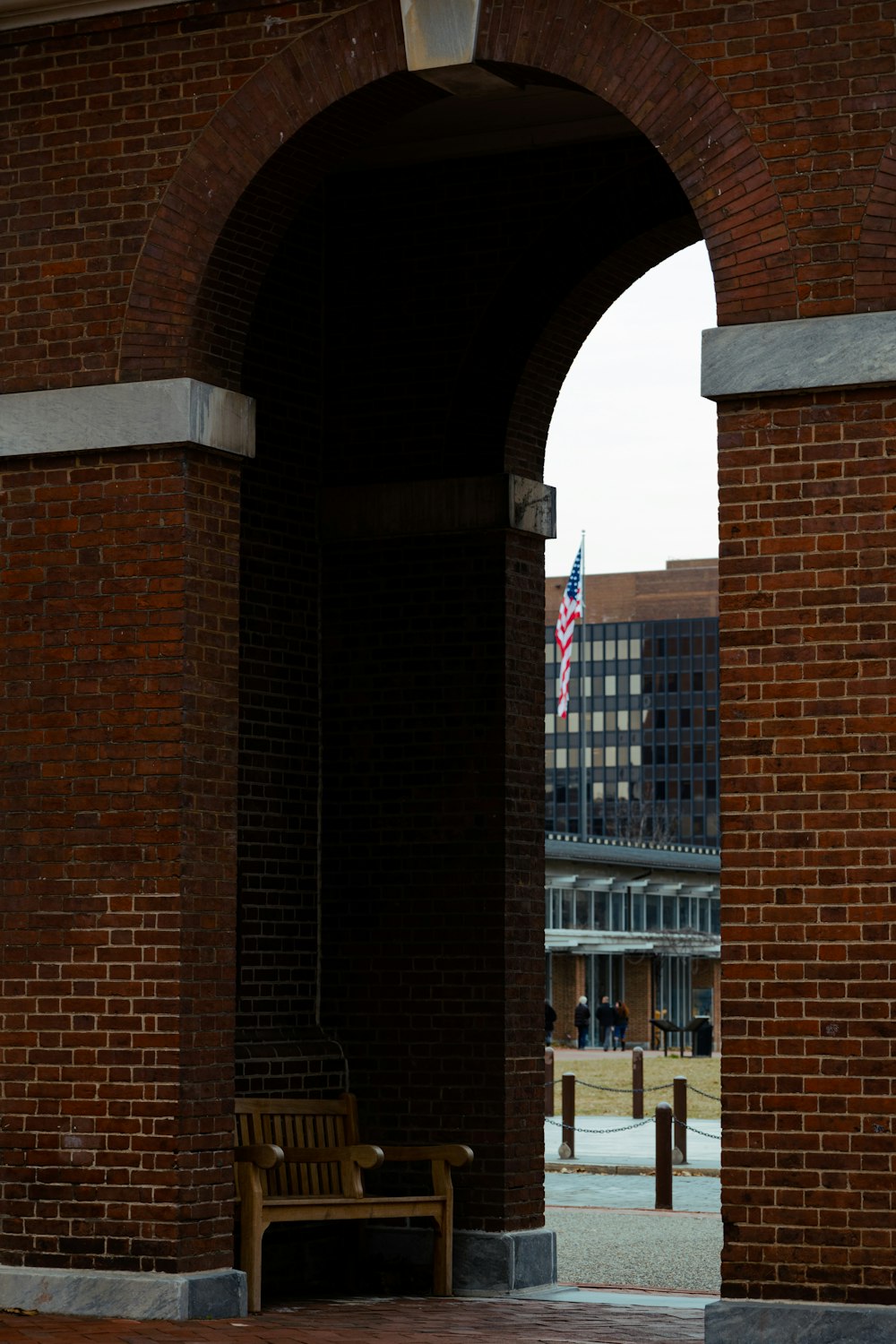 a bench sitting under an arch in a brick building