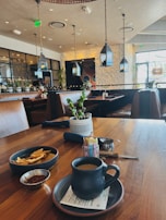 The cozy interior of the pancheria with black, white, and red decor, featuring customers enjoying their meals.