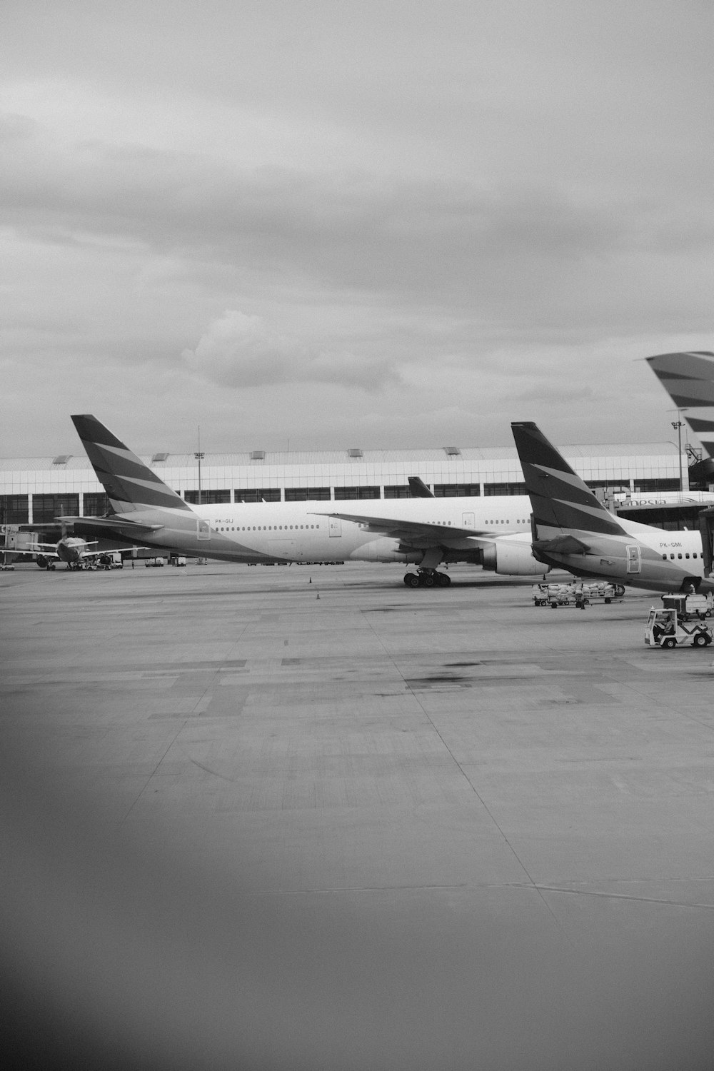 a black and white photo of two airplanes on the tarmac