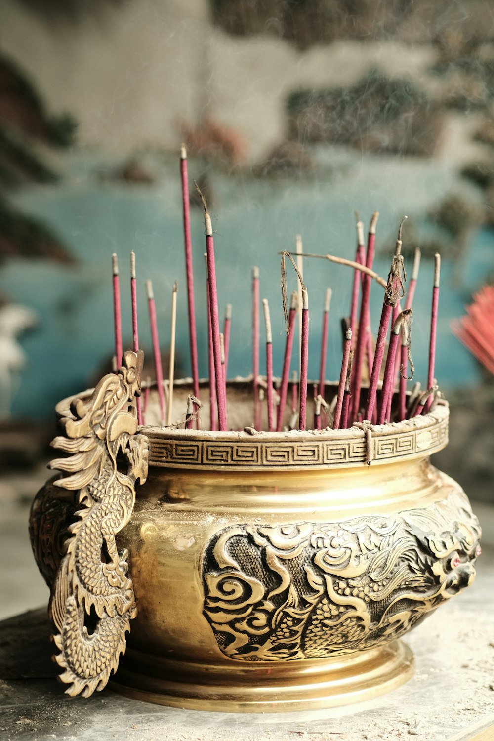 incense sticks in a brass bowl with a dragon decoration
