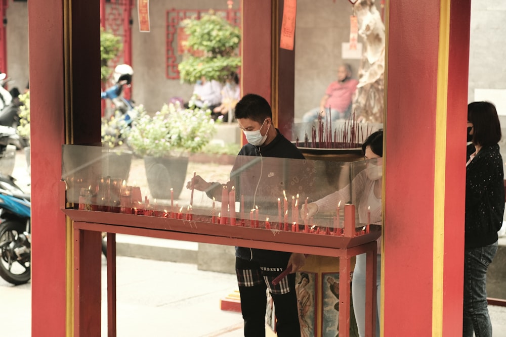 a man standing at a counter with candles in front of him