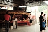 Volunteers serving warm meals to devotees under temple courtyard shade