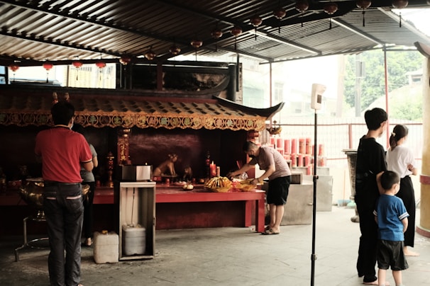 Volunteers arranging offerings and gifts at the temple entrance with smiles