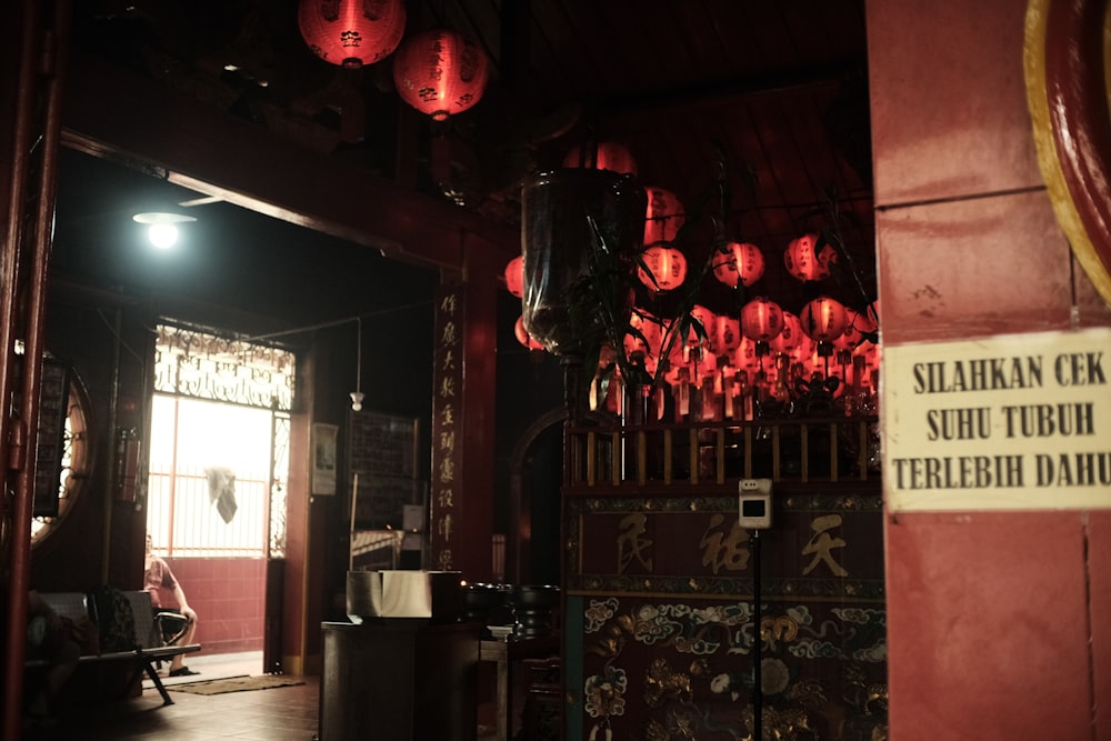 a room with a lot of red lanterns hanging from the ceiling