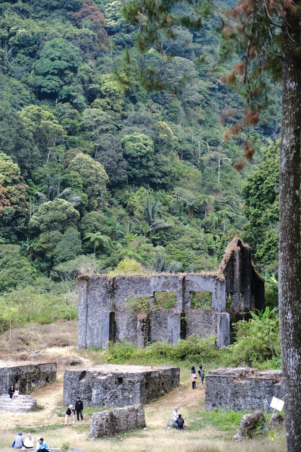 a group of people standing around a stone building