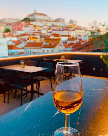 A chilled glass of tinto de verano resting on a sun-dappled terrace overlooking the Mediterranean Sea.