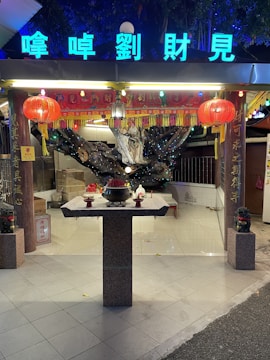 A completed small shrine decorated with flowers and lights.
