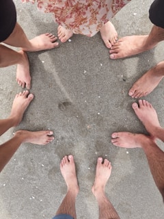 A warm, inviting circle of people dancing barefoot on a sunlit earth-toned floor.