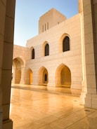 a white building with arches and a clock on it