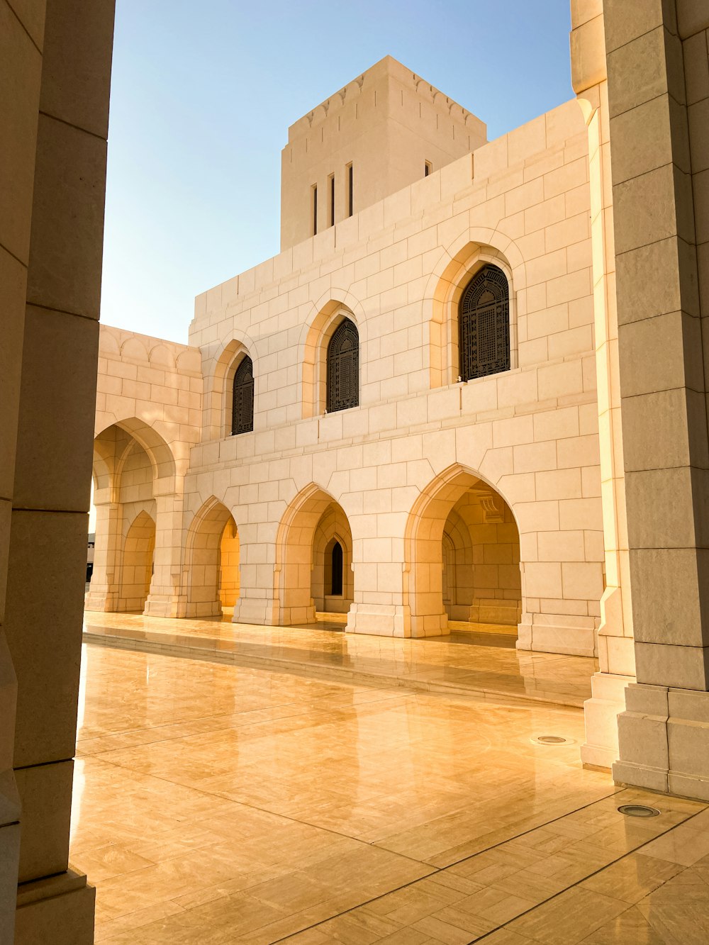 a white building with arches and a clock on it