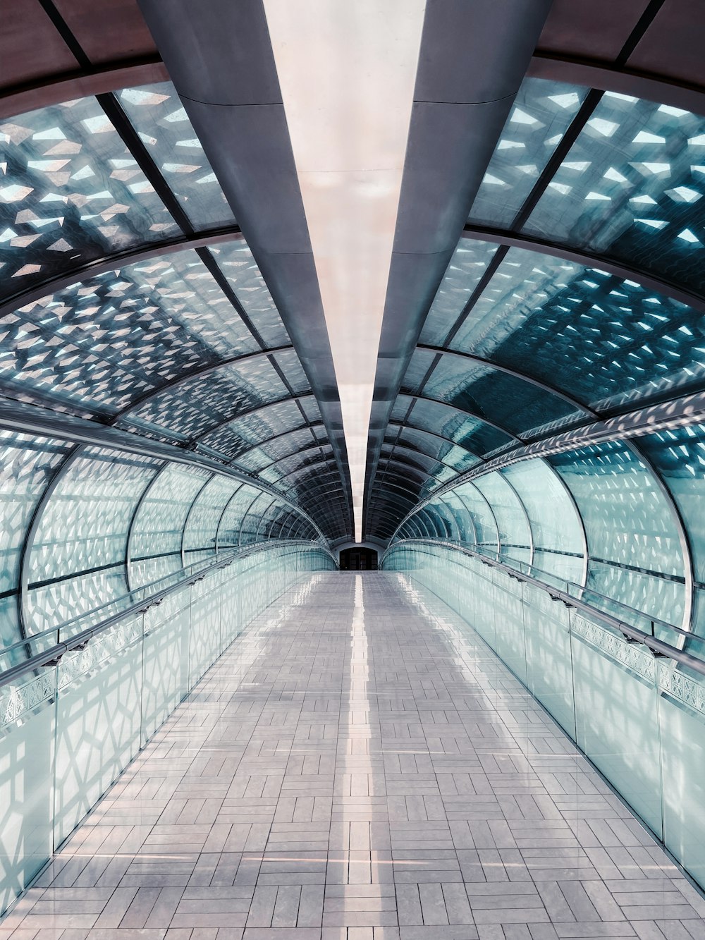 a walkway with a tiled floor and a skylight