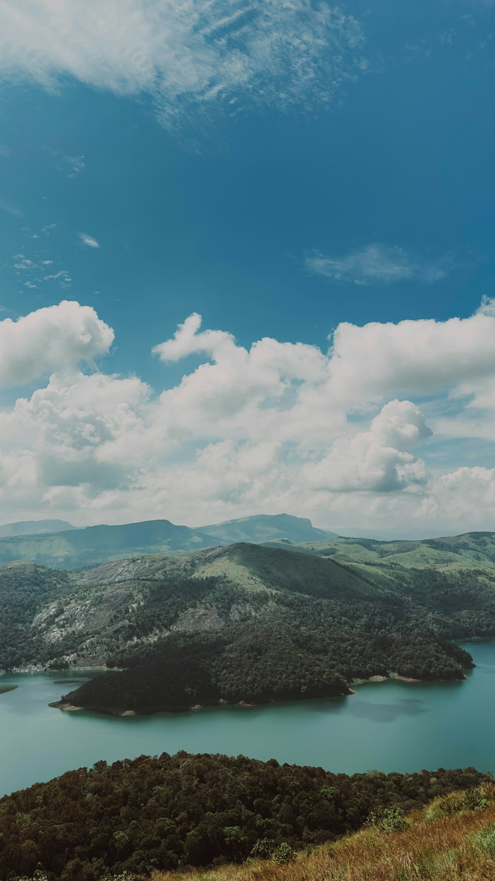 a view of a lake and mountains from a hill