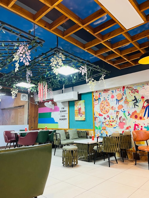 A vibrant, inviting restaurant interior with a table full of colorful pizzas, burgers, rolls, and sweets.