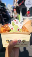 A cheerful delivery box with kawaii stickers being handed over at a doorstep.