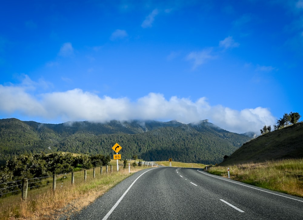 una carretera con una señal amarilla a un lado