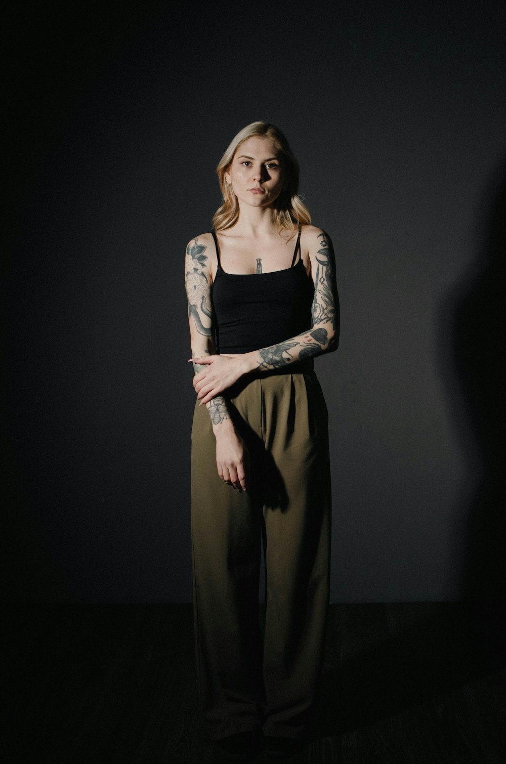 a woman with tattoos standing in a dark room