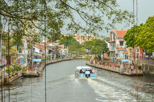 a boat traveling down a river next to tall buildings