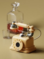 a toy phone sitting on top of a table next to a bottle