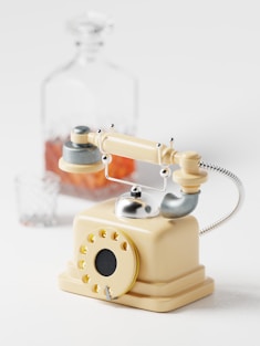 a toy phone with a glass bottle in the background