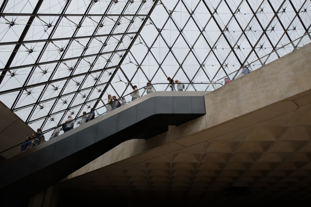 a group of people standing on top of a glass roof