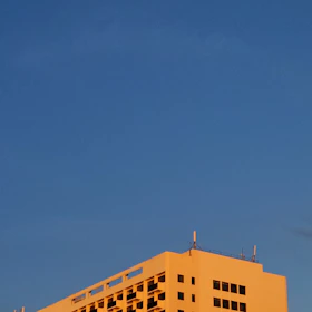 Wide shot of a large commercial building with a freshly coated, gleaming roof under bright sunlight.