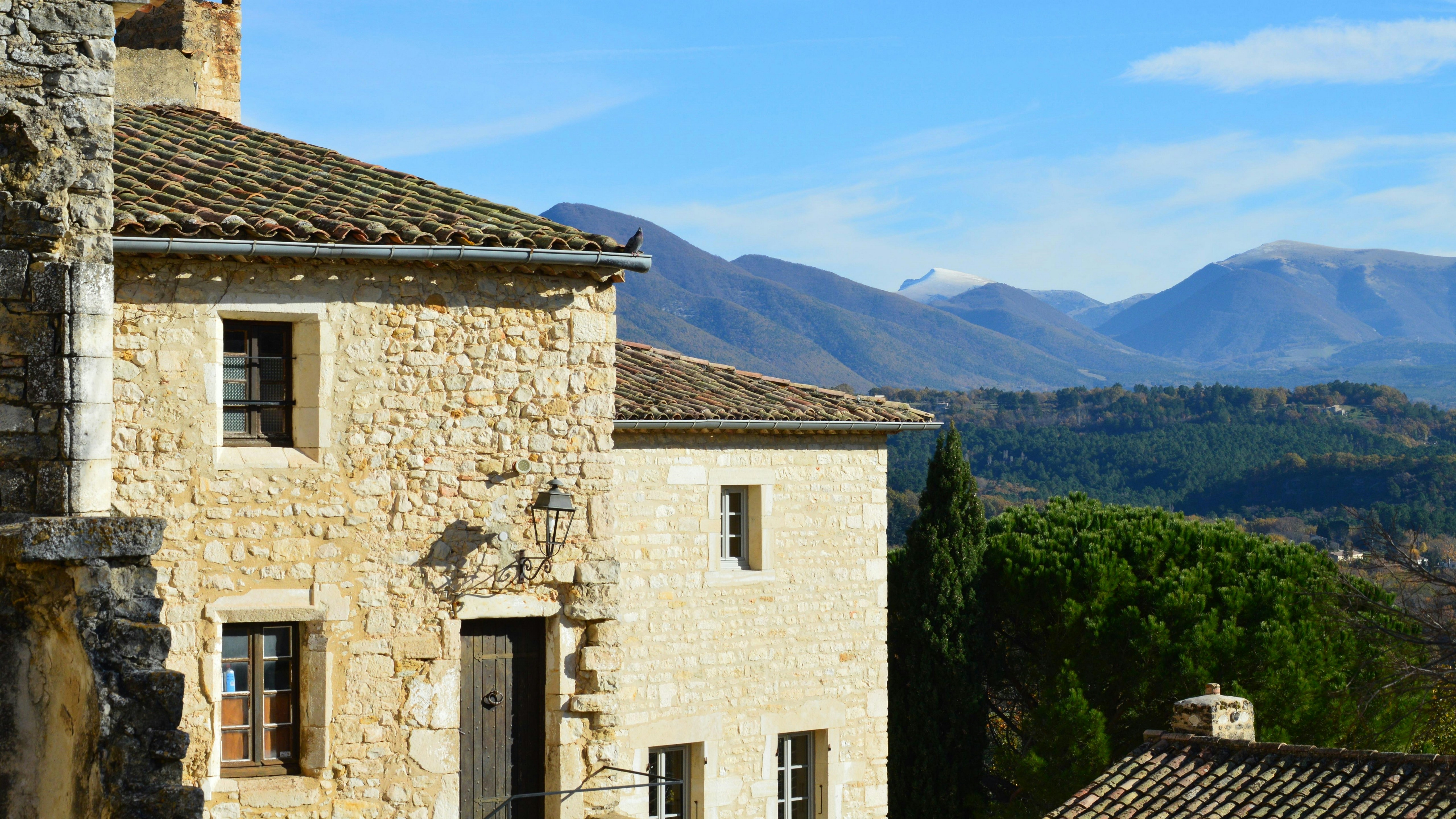 a stone house with mountains in the background