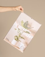 Hands holding a calendar marked with daily check-in reminders.