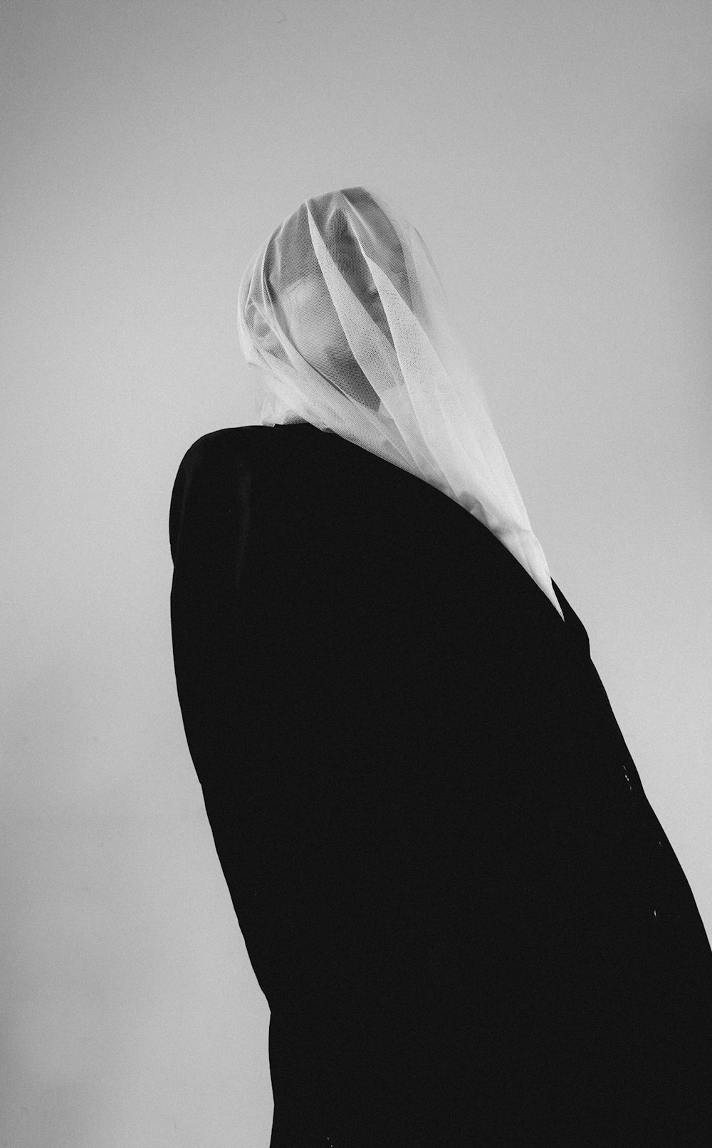 a black and white photo of a woman with a veil on her head