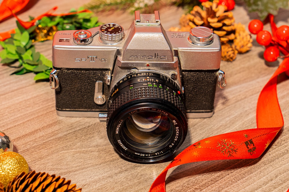 a silver camera sitting on top of a wooden table