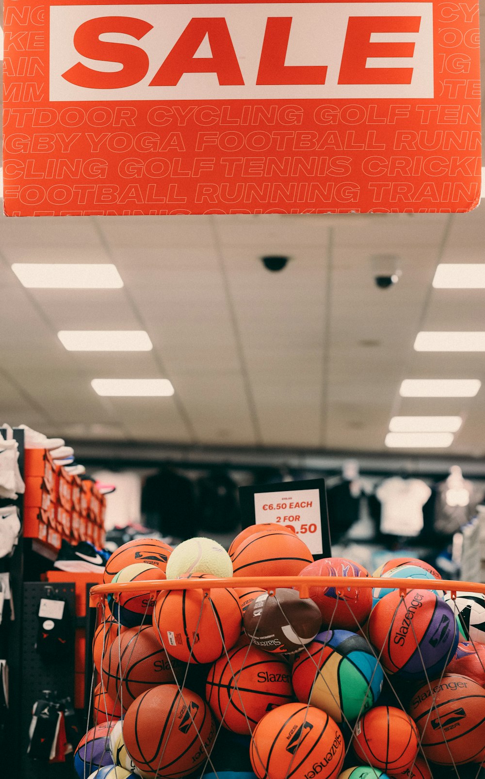 a basket full of basketballs for sale in a store