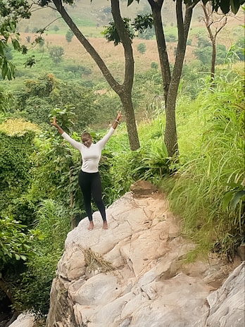 Joe standing on a rocky outcrop, surrounded by lush greenery and bright wildflowers.