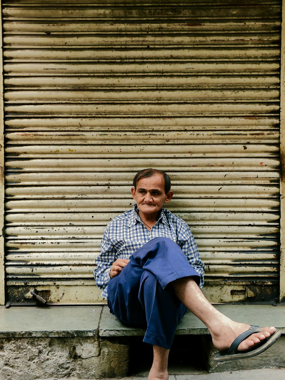 a man sitting on a bench in front of a building