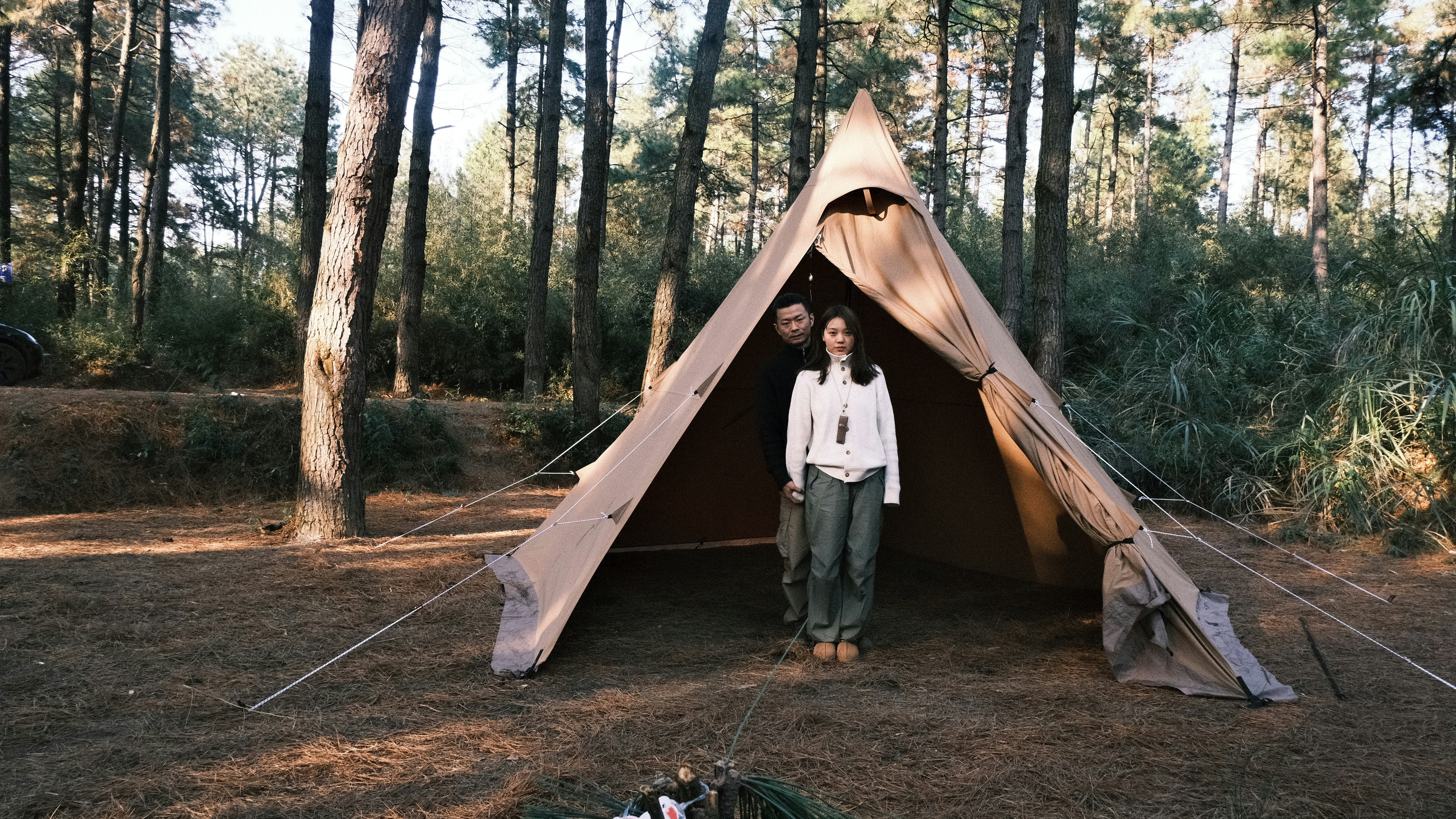 a woman standing in a tent in the woods