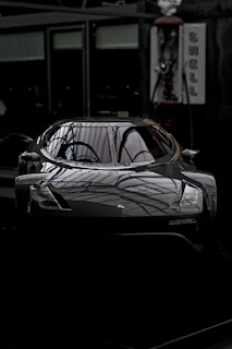 A sleek car with a glossy ceramic coating reflecting sunlight in a bright garage