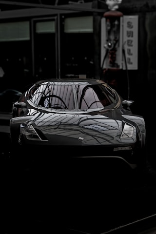 A sleek car gleaming under bright lights inside a modern, spotless garage studio in Ahmedabad.