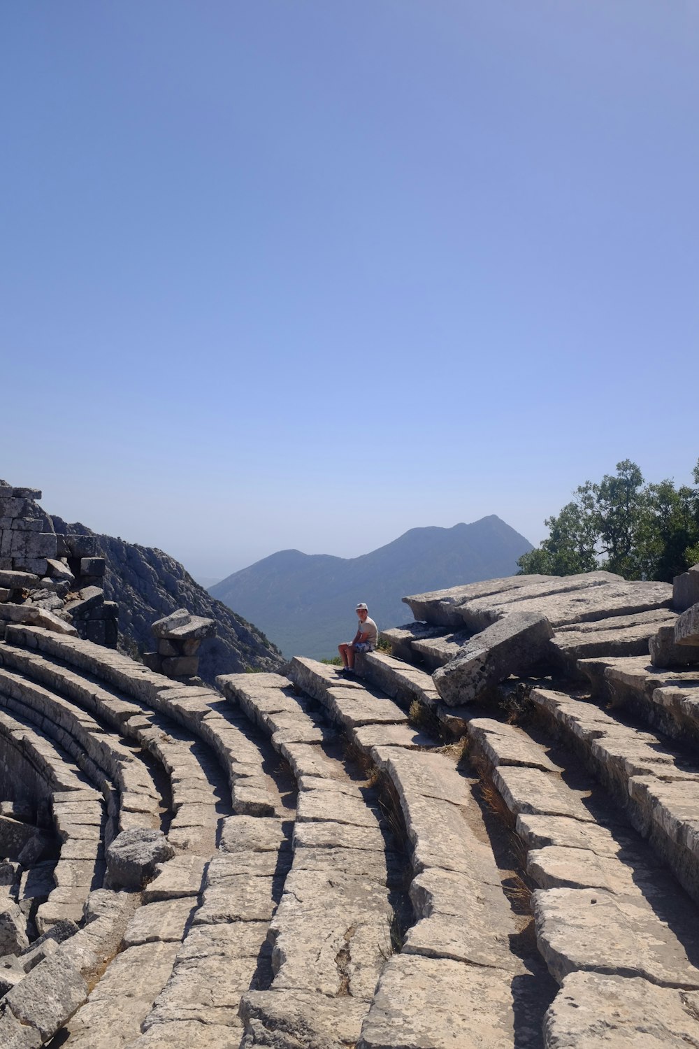 a man sitting on top of a stone structure