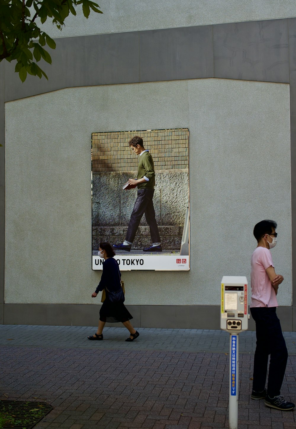 a couple of people walking past a parking meter