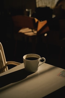 Minimalist coffee cup on a white table with soft natural light