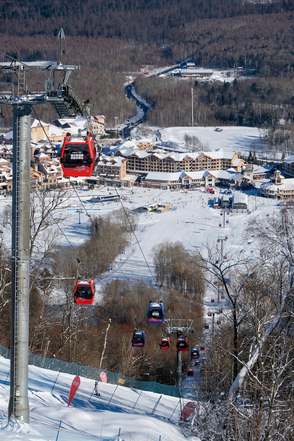 a ski lift going over a snow covered ski slope