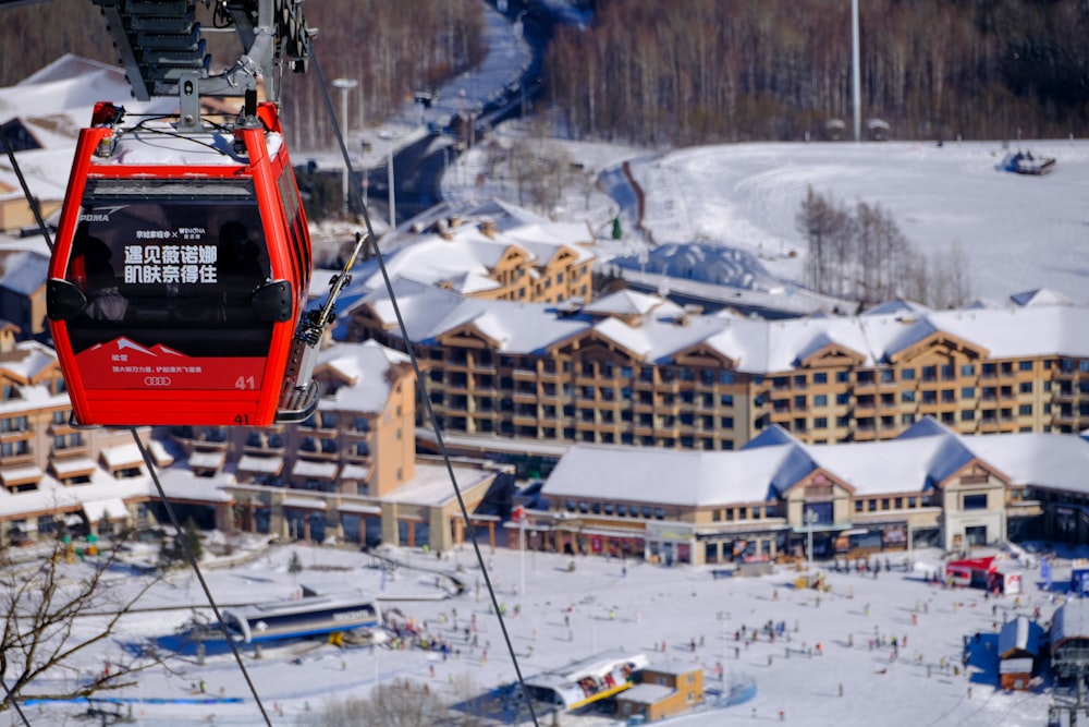 a red ski lift going up a snowy mountain